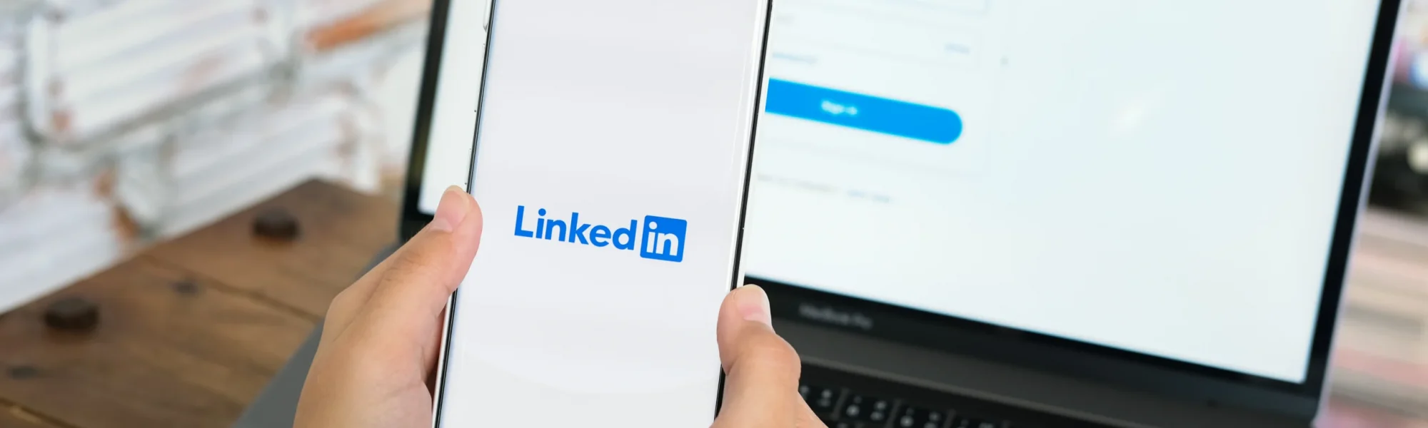 Tela do computador e celular com um perfil do LinkedIn aberto, em referência as estratégias para se destacar na plataforma.