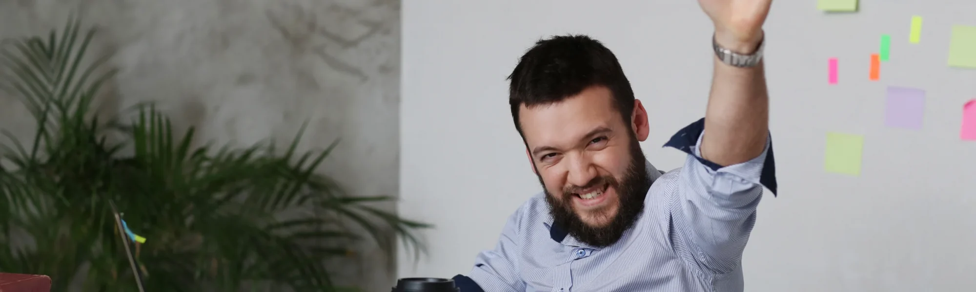 Homem feliz sentado na sua mesa de trabalho, empolgado por mudar de carreira