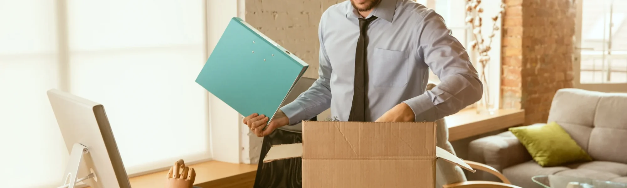 Homem arrumando sua mesa de trabalho após mudar de carreira.